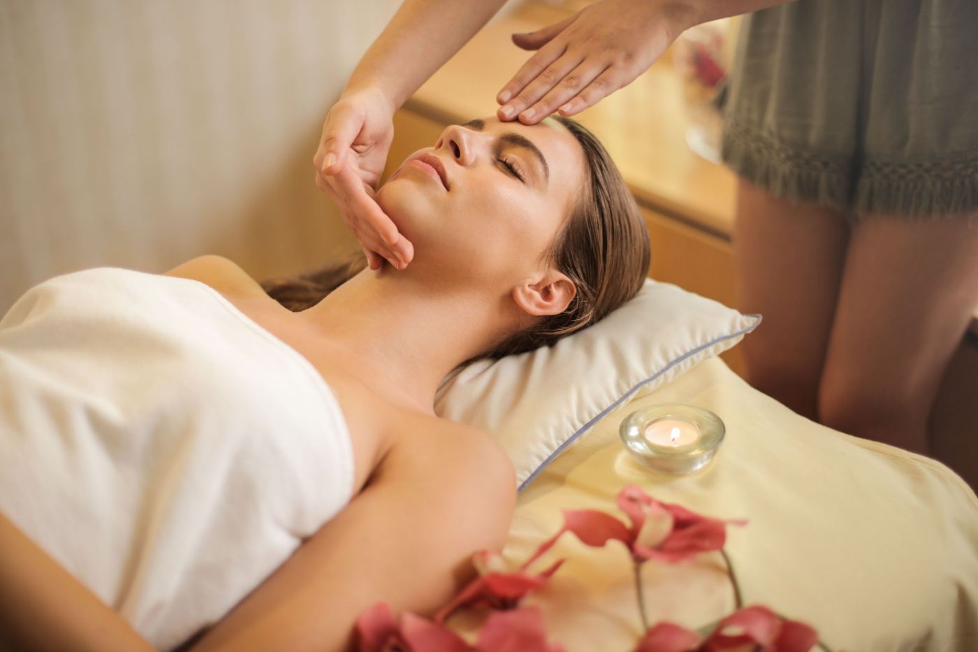 Paciente recostada con los ojos cerrados durante un tratamiento facial en cabina