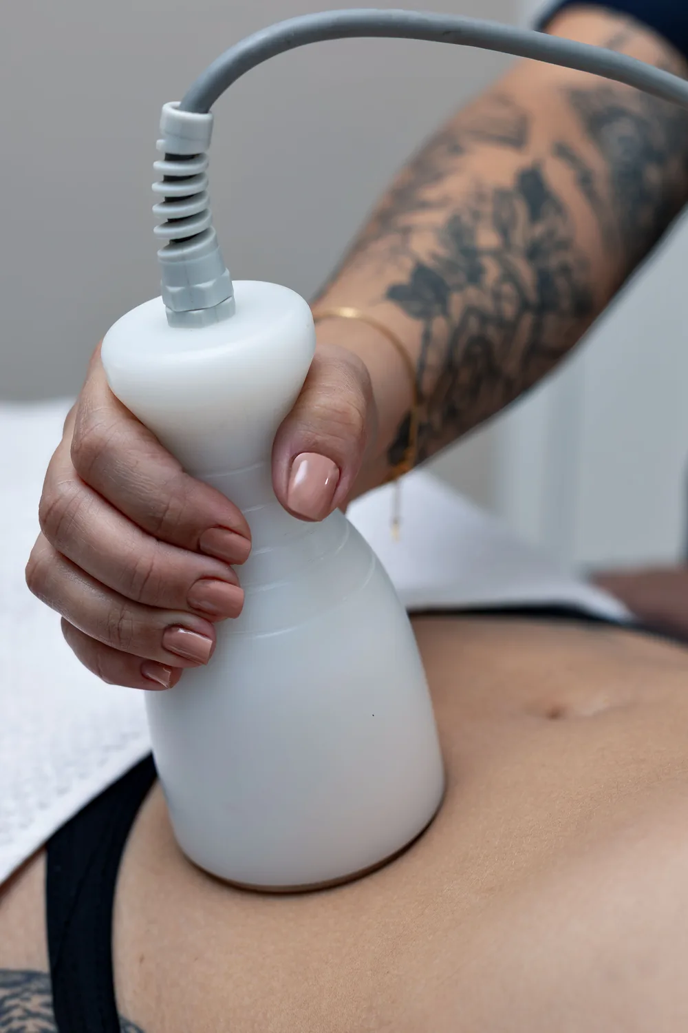 Cabezal de reafirmación cutánea aplicado por una profesional sobre el abdomen